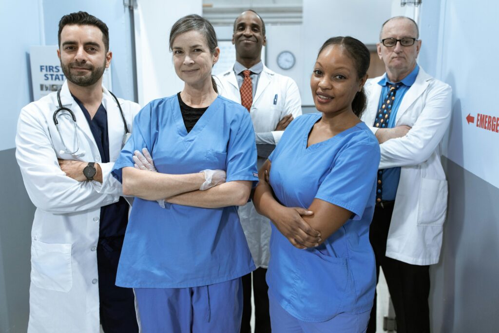 A diverse team of doctors and nurses smiling confidently in a hospital setting.